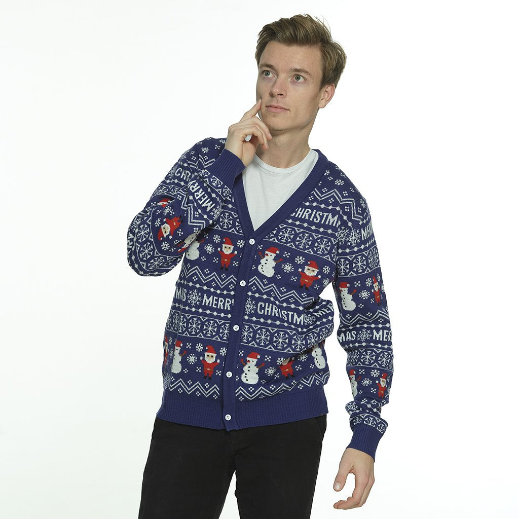 Un homme posant portant un gilet de Noël bleu avec des elfes et des bonshommes de neige.